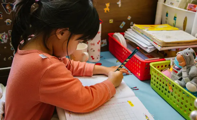 Child learning to write with their pencil